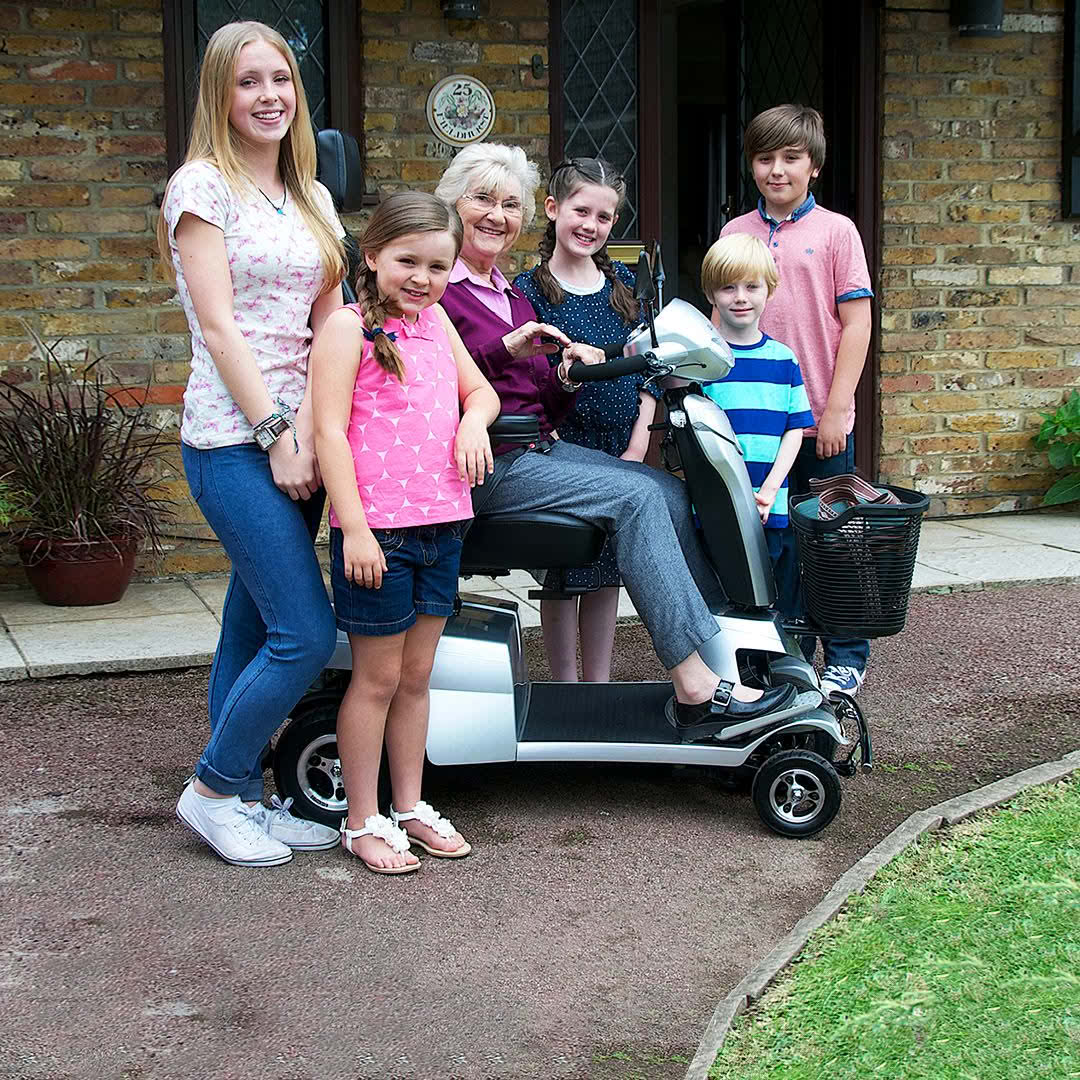A family with a scooter outside a house