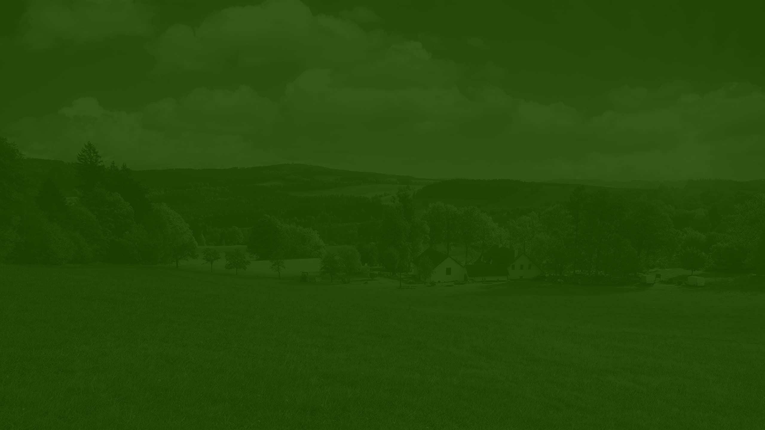 A dark green overlay placed on top of an image showing some countryside